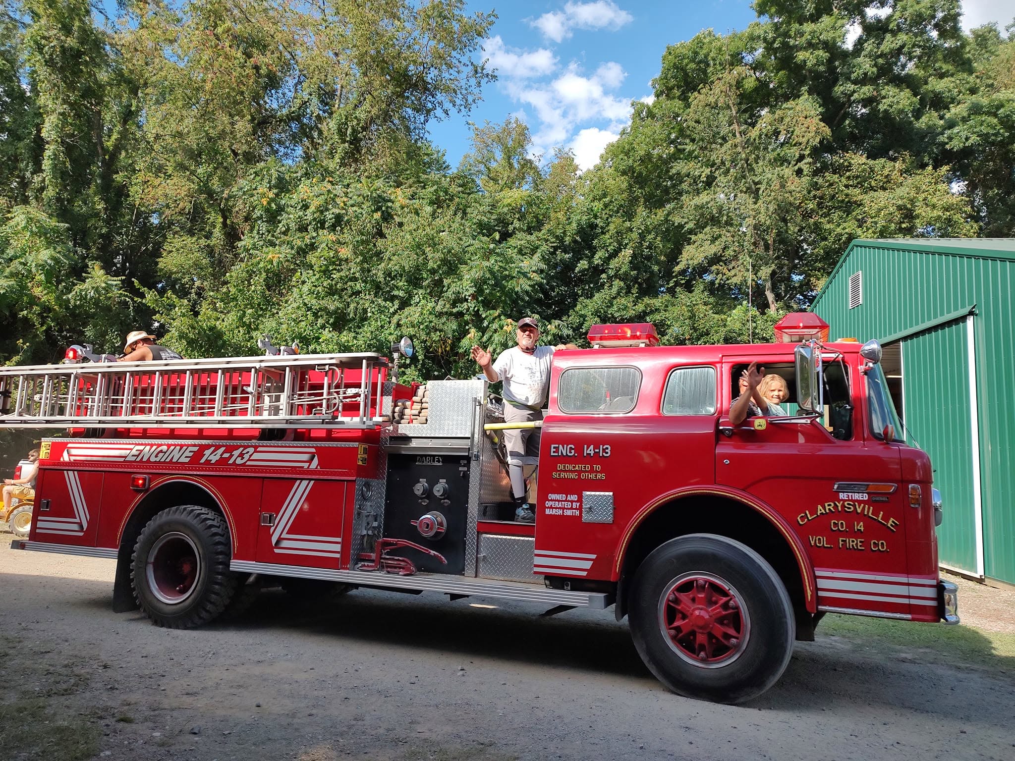 Clarysville Volunteer Fire Company vintage red ladder truck with riders waving
