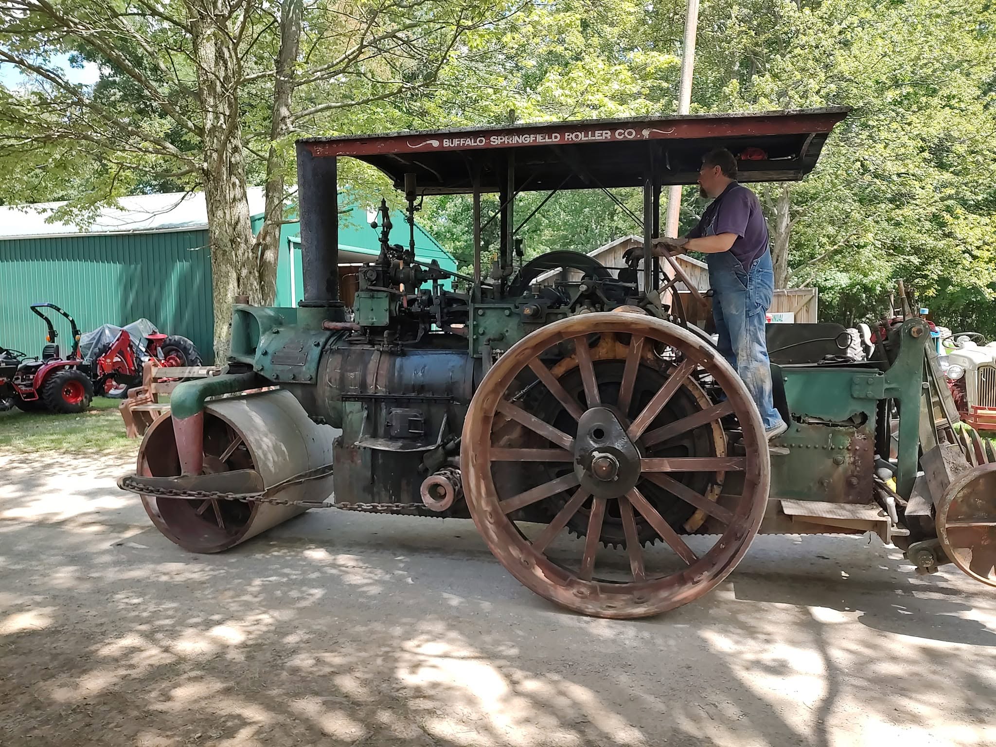 Green Buffalo-Springfield steam road roller parked in a shaded area at the show